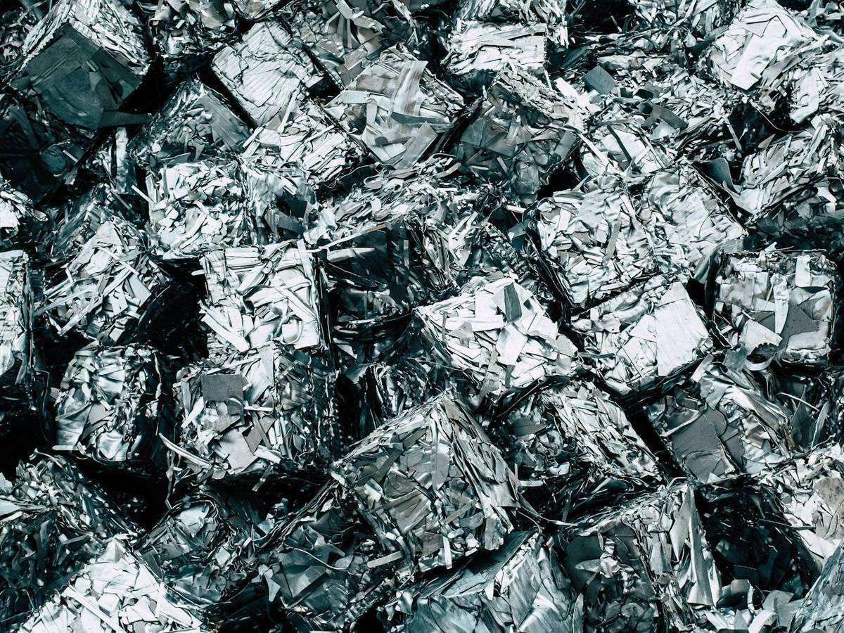 Crushed and baled scrap metal cubes stacked for recycling